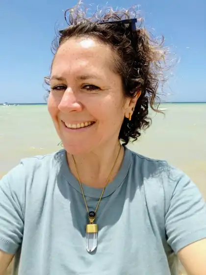 Rebeca, creadora de Reconéctate Contigo, sonriendo en la playa